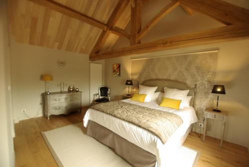 a bedroom with a large bed with yellow pillows at Les Maisons du Cheylard-Lascaux in Les Farges