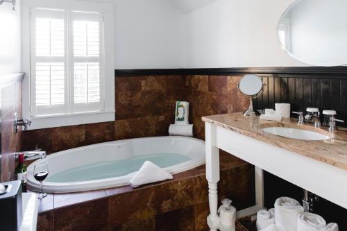 a bathroom with a tub and a sink at The Platinum Pebble Boutique Inn - Adults Only Property in Harwich Port