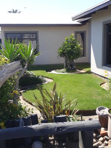 a yard with a bench in front of a house at Sunflower Self-Catering in Walvis Bay