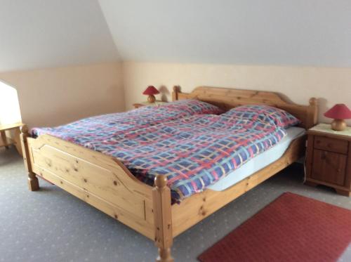 a bedroom with a wooden bed with two lamps on it at Ferienwohnung Albers in Blomberg