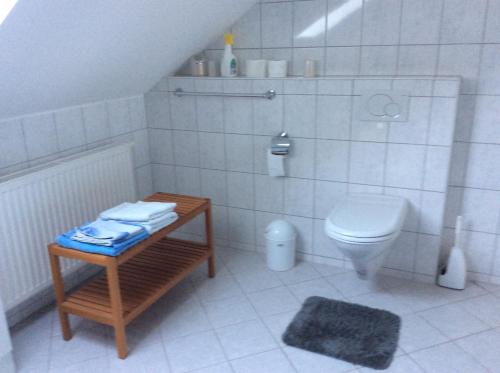 a white bathroom with a toilet and a table at Ferienwohnung Albers in Blomberg