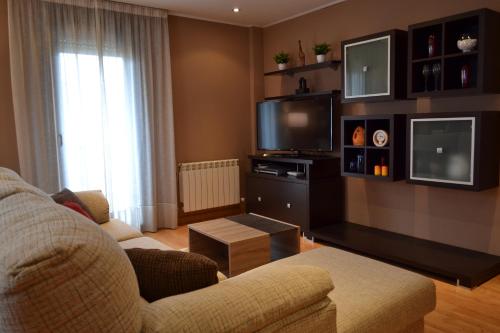 a living room with a couch and a flat screen tv at Apartamento Nuevo Baztan in Elizondo