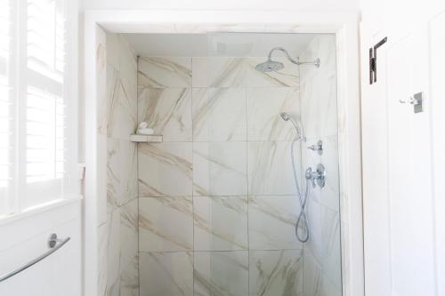 a bathroom with a shower with marble tiles at The Platinum Pebble Boutique Inn - Adults Only Property in Harwich Port