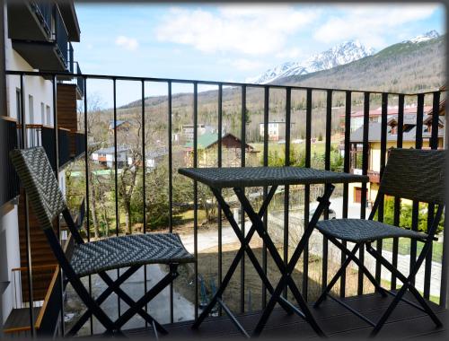 a table and two chairs on a balcony with mountains at Meridián-apartmán, Starý Smokovec, PRIMO, Vysoké Tatry in Smokovce