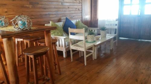 a dining room with a table and some chairs at Pura Vida Lodge in Morrumbene