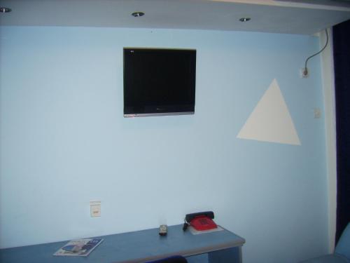 a living room with a tv on a white wall at Hotel "Srbija Tis" in Zaječar