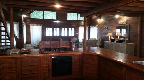 a kitchen with a counter in a room with windows at Pura Vida Lodge in Morrumbene