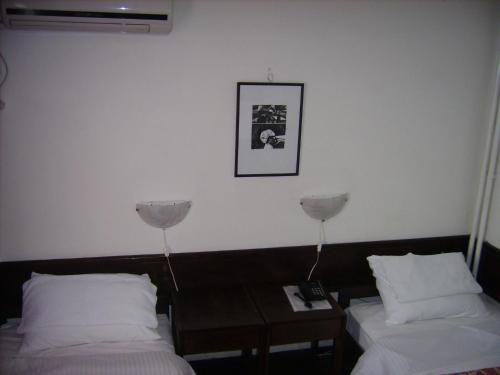 a hotel room with two beds and a table at Hotel "Srbija Tis" in Zaječar