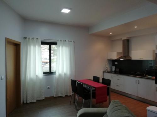 a living room with a table and a kitchen at Sweet Home for Holidays in Machico