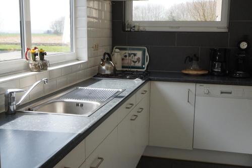 eine Küche mit Spüle und Arbeitsplatte in der Unterkunft de Paardenmarkt in Aardenburg
