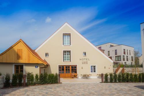 a large white building with a wooden roof at Hotel Luis Stadl in Regensburg