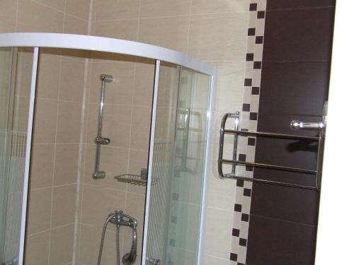 a shower with a glass door in a bathroom at Pensiunea Caramell in Cluj-Napoca
