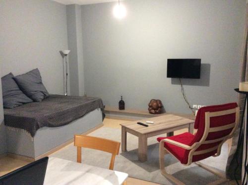 una pequeña sala de estar con cama y mesa. en Renovated apartment en Athens