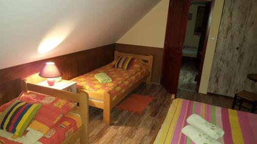 a small room with two beds and a lamp on a table at Holiday Home Di More in Jagodina