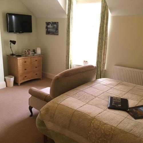 a bedroom with a bed and a television and a dresser at Burnside B&B in Keswick