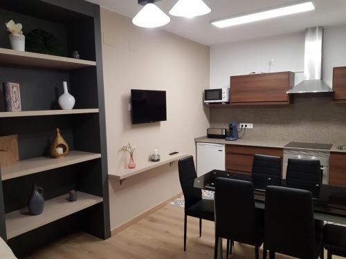 a kitchen and dining room with a table and chairs at Casa de Campo Cruz de Pedra in Portomarin