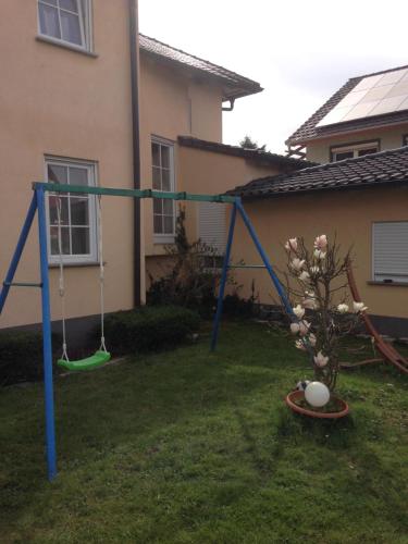 a swing set in the yard of a house at Gästehaus Tante Tienchen 7 Minuten zu Fuss zum Europa Park , plus kostenloses Parkplatzticket Rulantica ,alle unsere Suiten haben einen Balkon in Rust