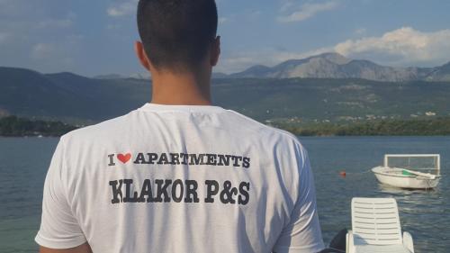 a young man standing on a dock looking at the water at Apartments Klakor PS in Tivat