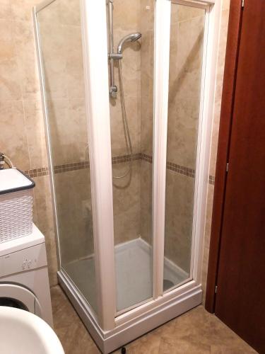 a shower with a glass door in a bathroom at Beach Apartment in Rafailovici