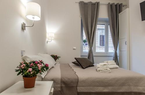 ローマにあるMr. Charlie Brownの白いベッドルーム(花の飾られたベッド付)