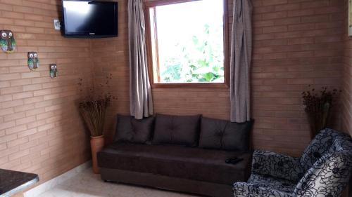 a living room with a couch and a window at Fazenda Rosmaninho in Alto Paraíso de Goiás