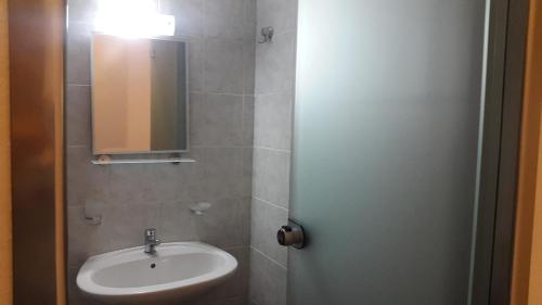 W łazience znajduje się umywalka i lustro. w obiekcie Joanna Apartments w mieście Balíon