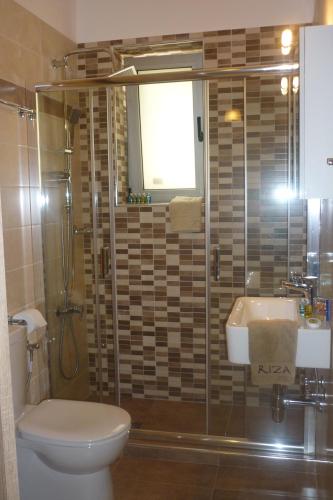 a bathroom with a shower and a toilet and a sink at Riza Apartments in Kardamili