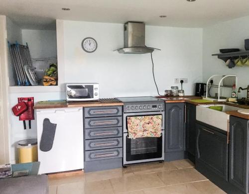a kitchen with an oven and a counter top at Garden Apartment in Grange Over Sands
