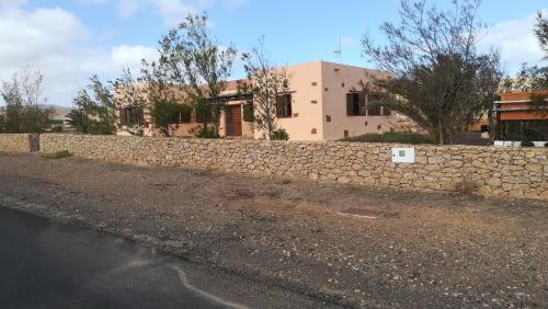 a stone retaining wall in front of a house at Casa Serena in Llanos de la Concepción