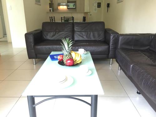a coffee table with a pineapple and fruit on it at Blue Waters Apartments in Gold Coast