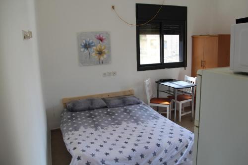um quarto com uma cama num quarto com um frigorífico em Apartments With Sea View em Haifa