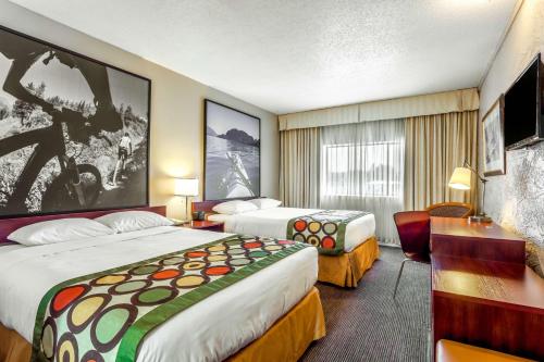 a hotel room with two beds and a desk at Super 8 by Wyndham Duncan in Duncan