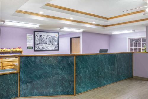 a waiting room with a green counter and purple walls at Super 8 by Wyndham Sweet Springs in Sweet Springs