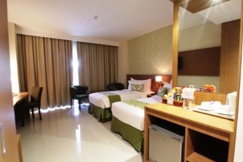 a hotel room with a bed and a desk at Ijen Suites Resort & Convention in Malang