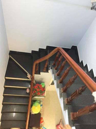 a staircase with black treads and wooden railings at Cat Ba Mystery Homestay in Cat Ba