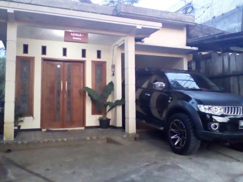 ein schwarzer SUV vor einem kleinen Haus geparkt in der Unterkunft Azalea Homestay in Batu