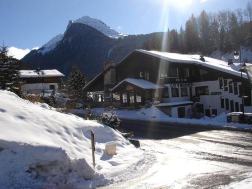 a building in the snow in front of a mountain at Hotel Le Soly in Morzine