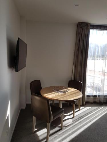 a dining room with a table and chairs and a window at Wyndham Garden Remarkables Park Queenstown in Queenstown