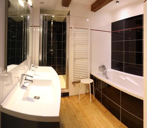 Maison d'hotes Sainte Genevieve في Sainte-Geneviève: حمام مع حوض غسيل أبيض وحوض استحمام