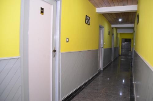 an empty hallway with yellow walls and yellow walls at JC Woodville Manor in Kodaikānāl