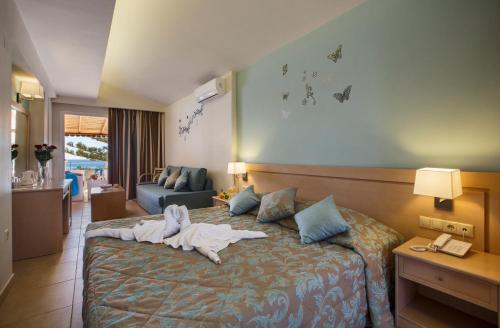 Una habitación de hotel con una cama con una toalla. en Tolon Holidays Hotel, en Tolo