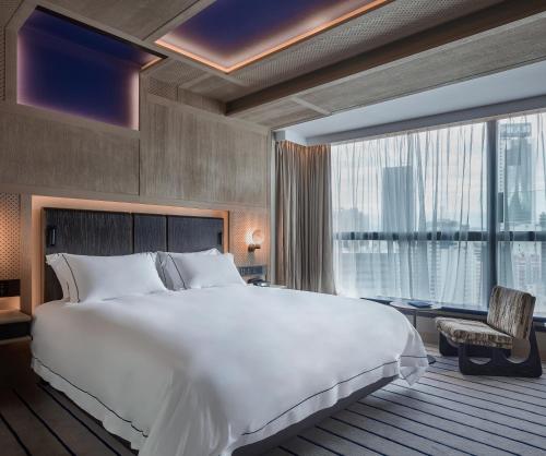 a bedroom with a large bed and a large window at The Emperor Hotel in Hong Kong