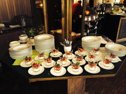 a table with plates and cups and dishes on it at Hotel BB Bahnhof Bertsdorf in Olbersdorf