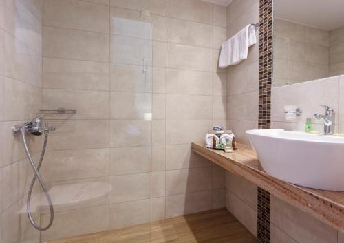 een badkamer met een wastafel en een douche bij Tolon Holidays Hotel in Tolo
