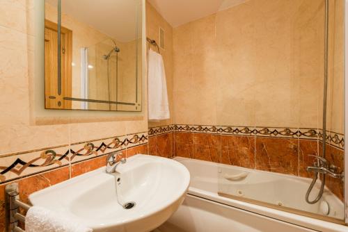 奧羅佩薩德爾馬的住宿－Vistamar Departamento，一间带水槽、浴缸和镜子的浴室
