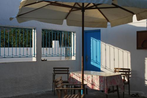 a table with an umbrella in front of a building at Anixi in Astypalaia Town
