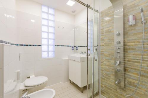 a bathroom with a shower and a toilet and a sink at Hotel Viking in Rimini