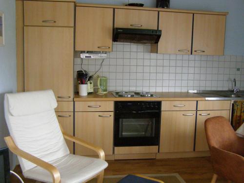 a kitchen with a white chair and a stove at blaues Haus am See in Schwarz