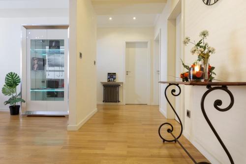 a hallway with a table with flowers on it at The Queen Luxury Apartments - Villa Carlotta in Luxembourg