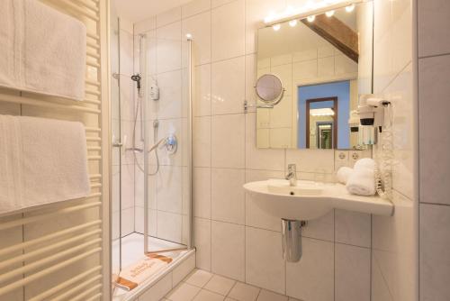 biała łazienka z umywalką i prysznicem w obiekcie Schloss Döttingen w mieście Braunsbach